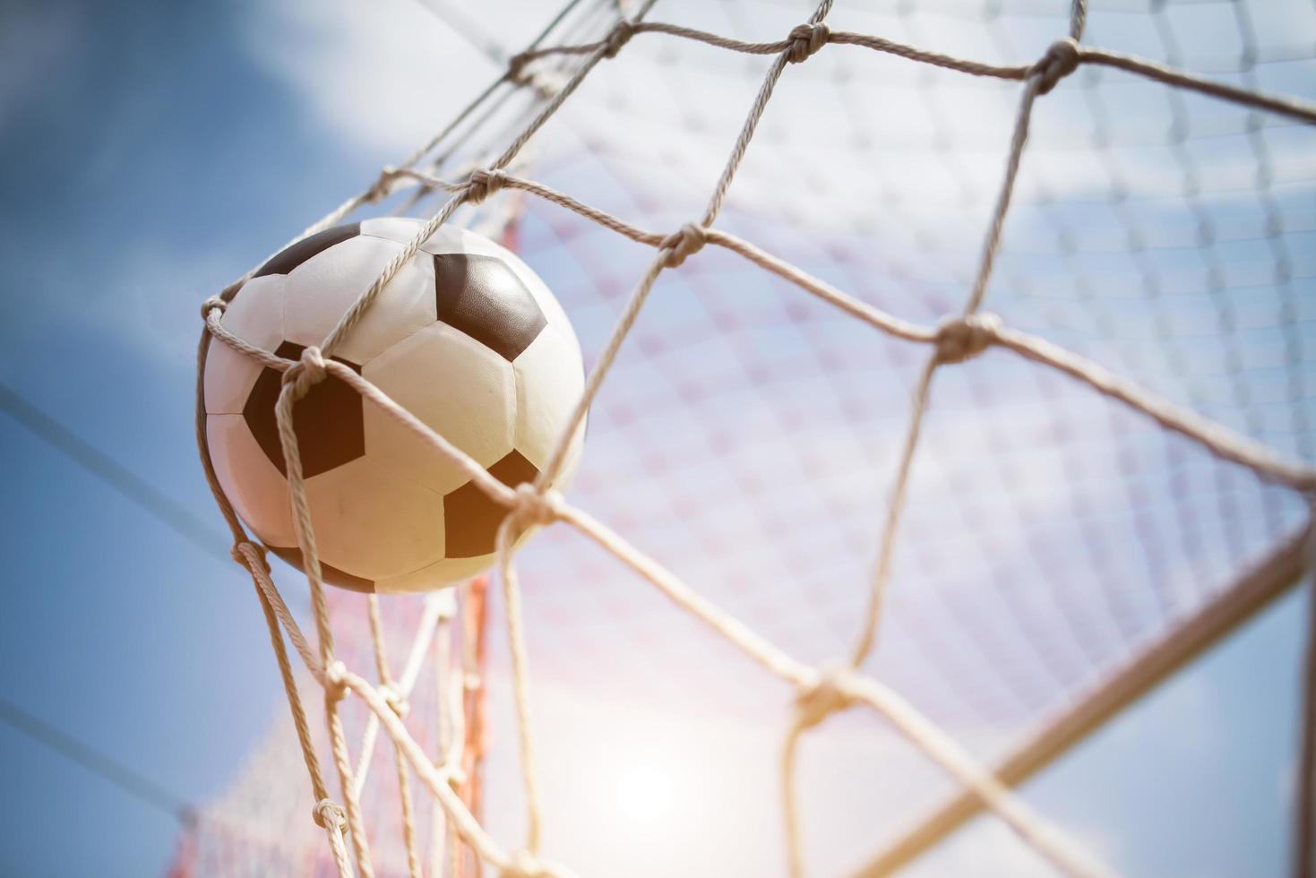 balón de fútbol se eleva a la red de la portería foto