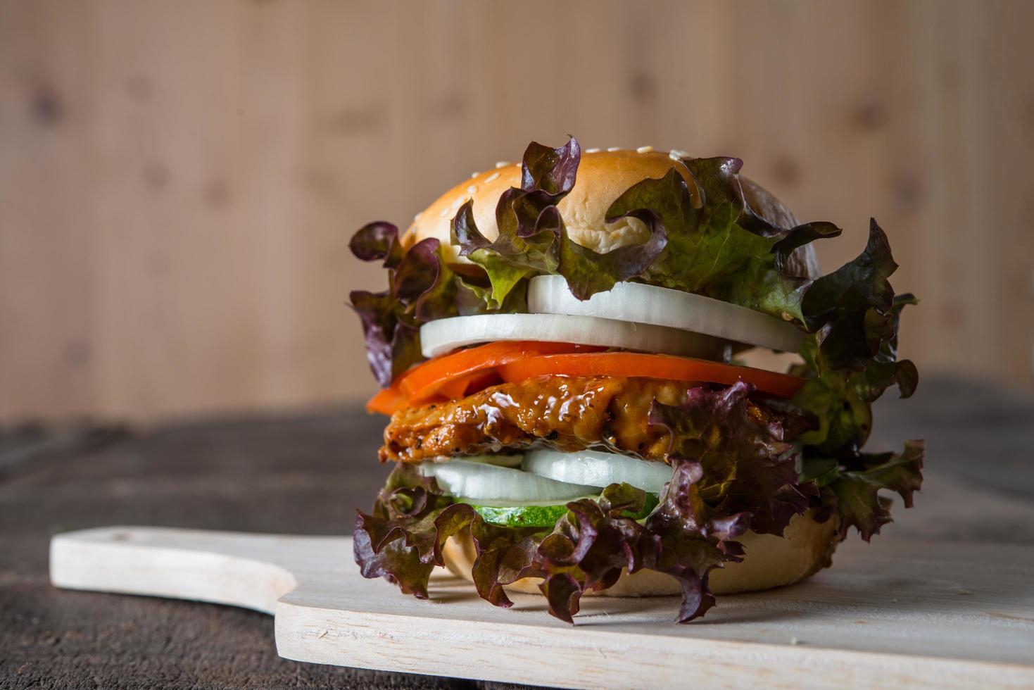 Homemade chicken burger with lettuce, tomato and onion photo