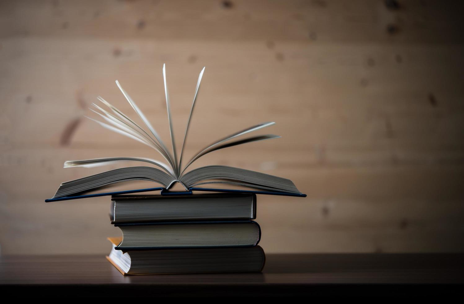 Stack of open books on a wooden table photo