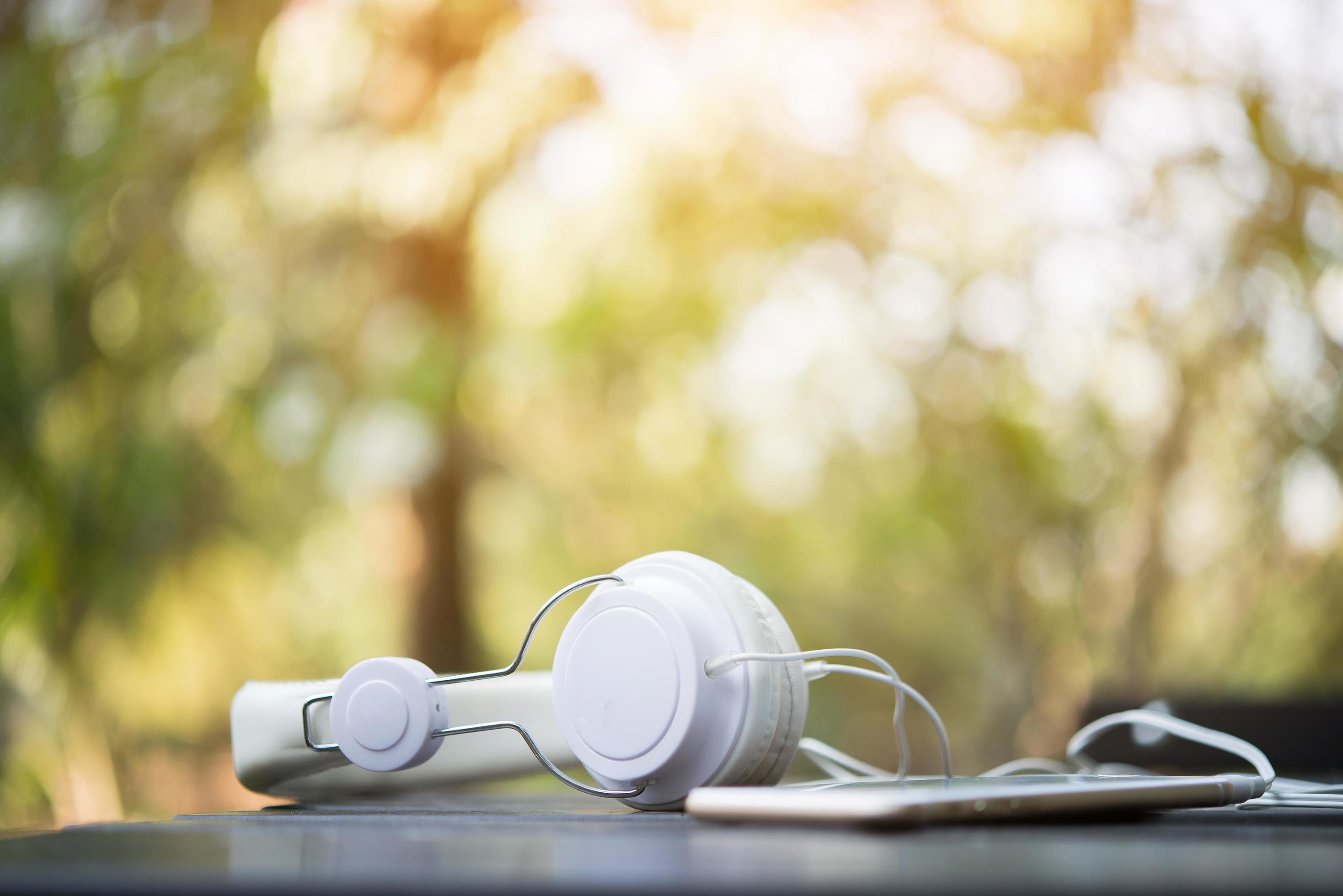 White headphones on wooden table with nature background 1781326 Stock Photo  at Vecteezy