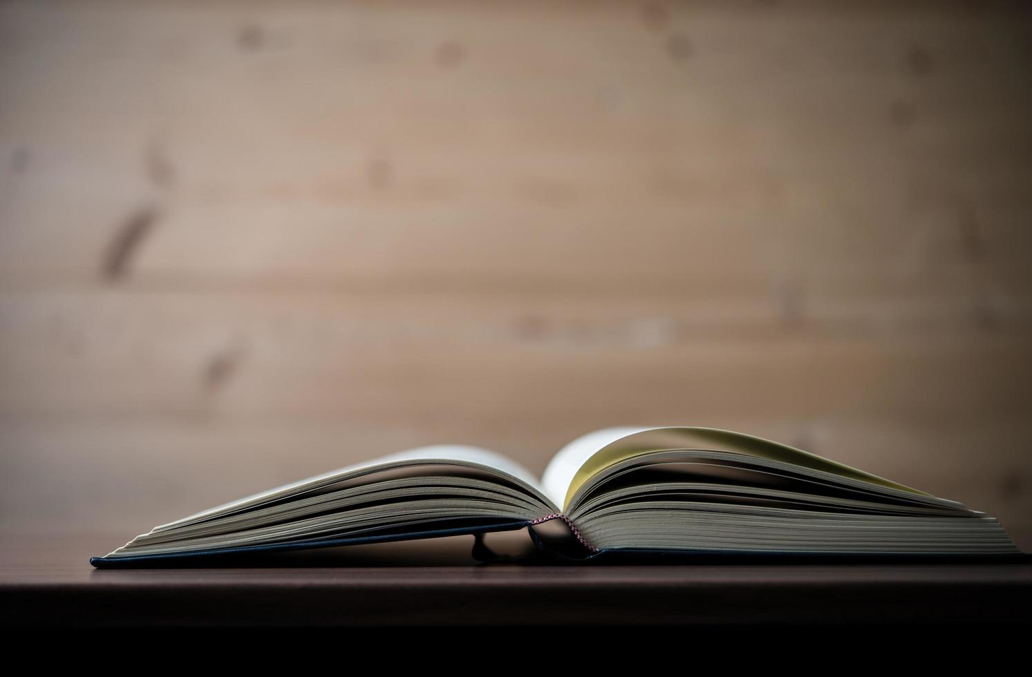 Close-up of an opened book on a wooden table photo