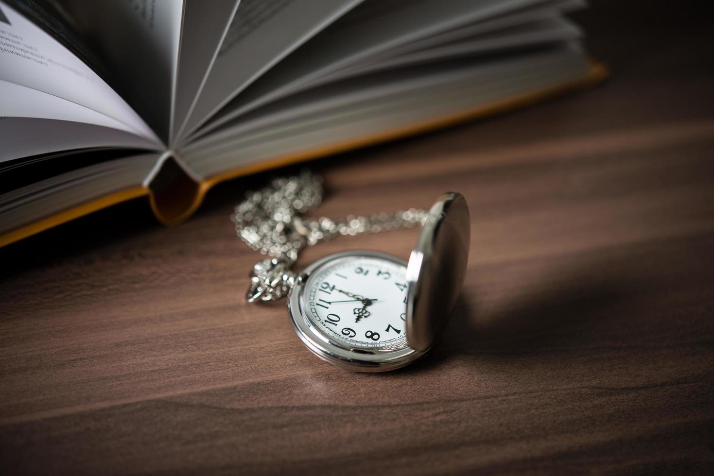 Close-up of a golden pocket watch and a book photo