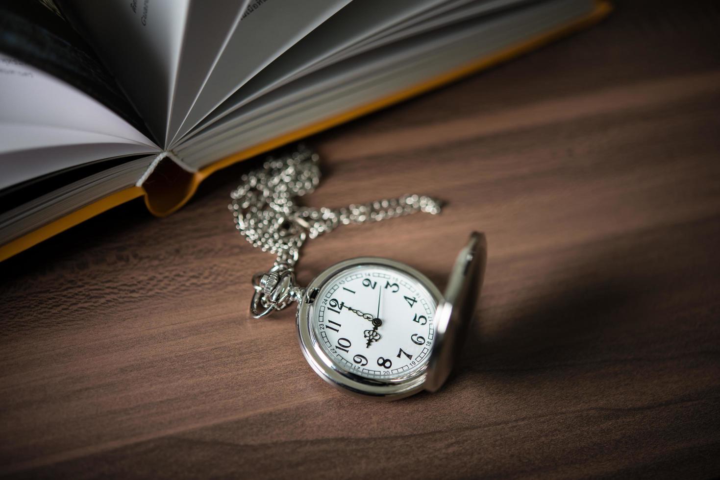 Close-up of a golden pocket watch and a book photo