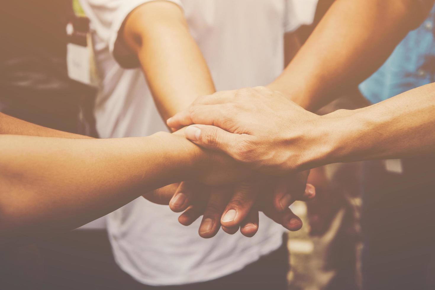 Several people join hands together photo