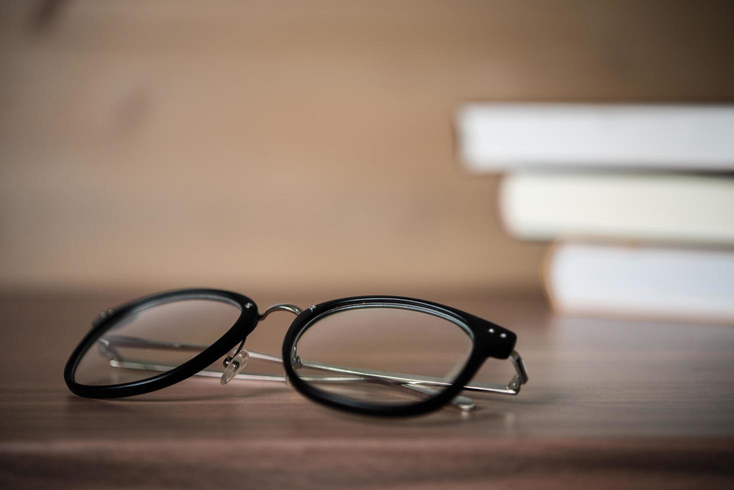 Glasses on a wooden table with books photo