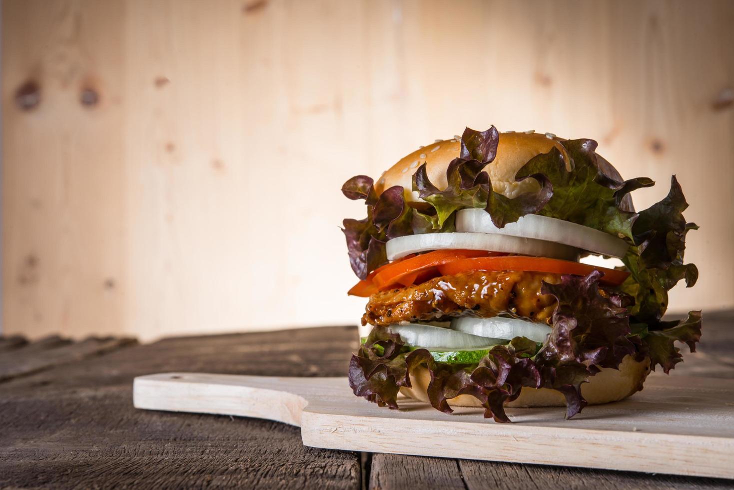 hamburguesa casera de pollo con lechuga, tomate y cebolla foto