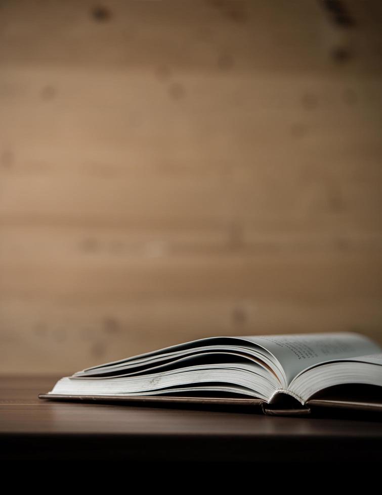 Close-up of an opened book on a wooden table photo