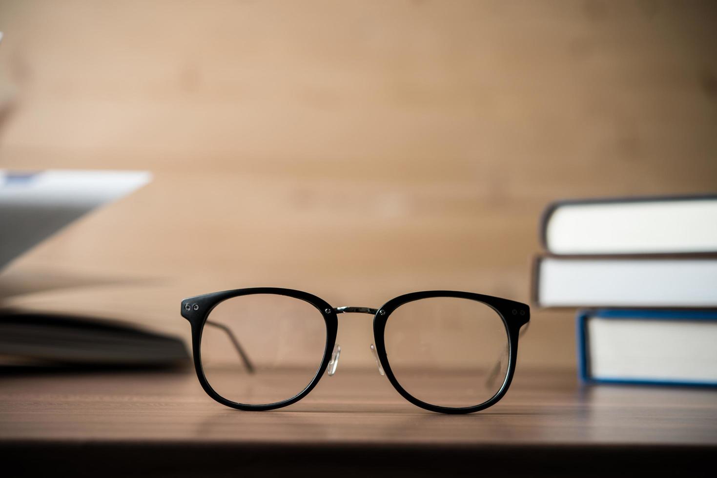 Glasses on a wooden table with books photo