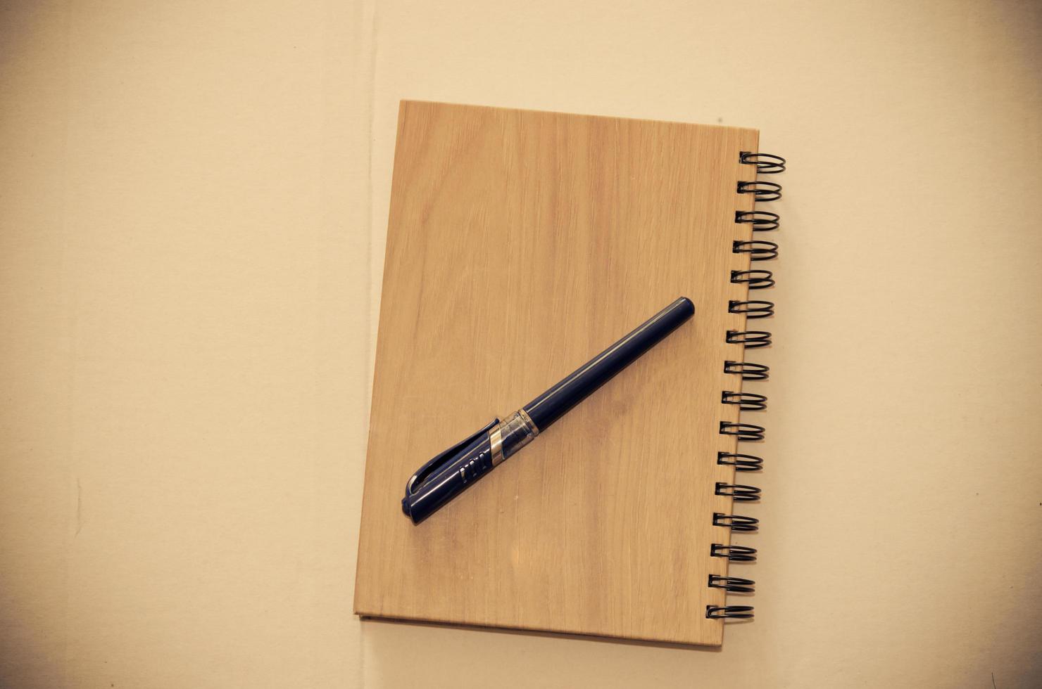 Top view of a wooden notebook and pen photo