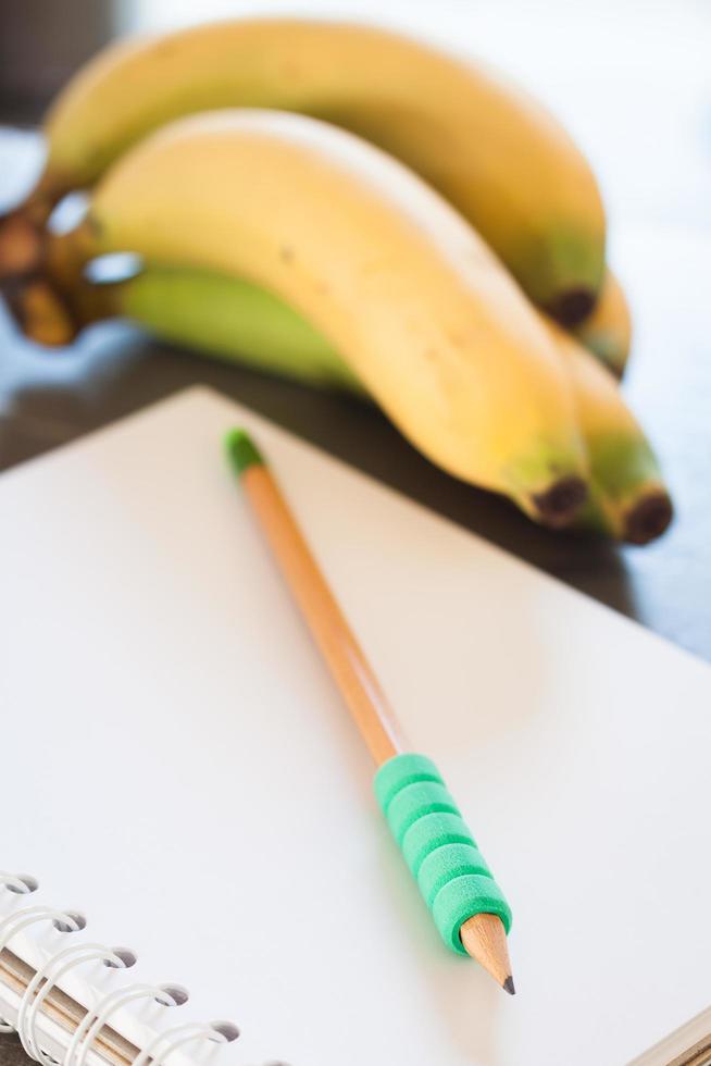 Pencil on a notebook with fruit photo