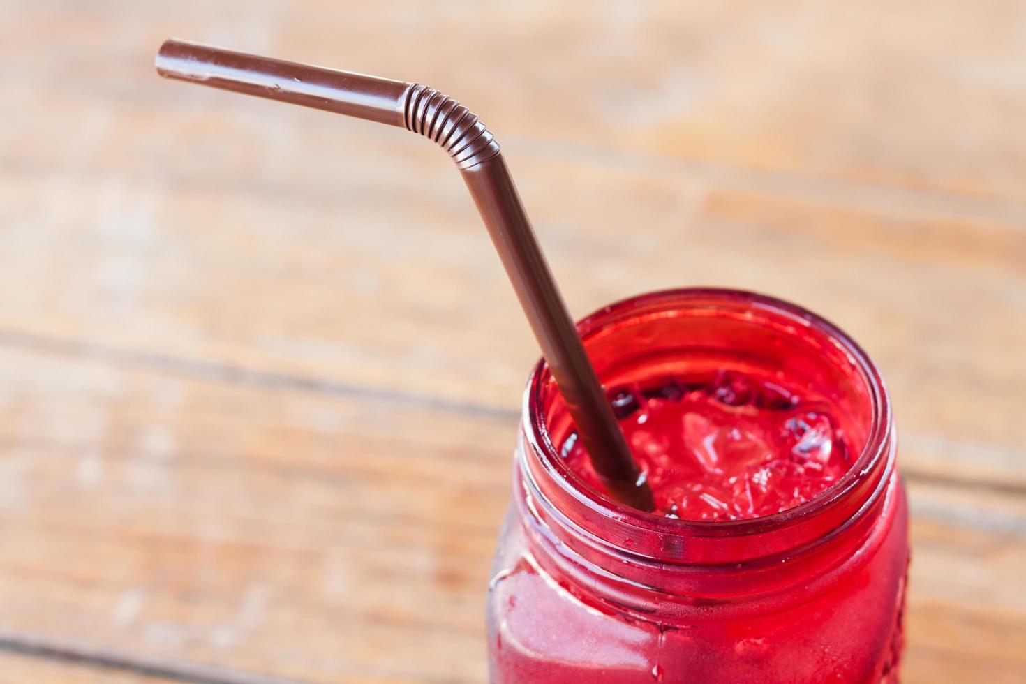 Red glass jar with a straw photo