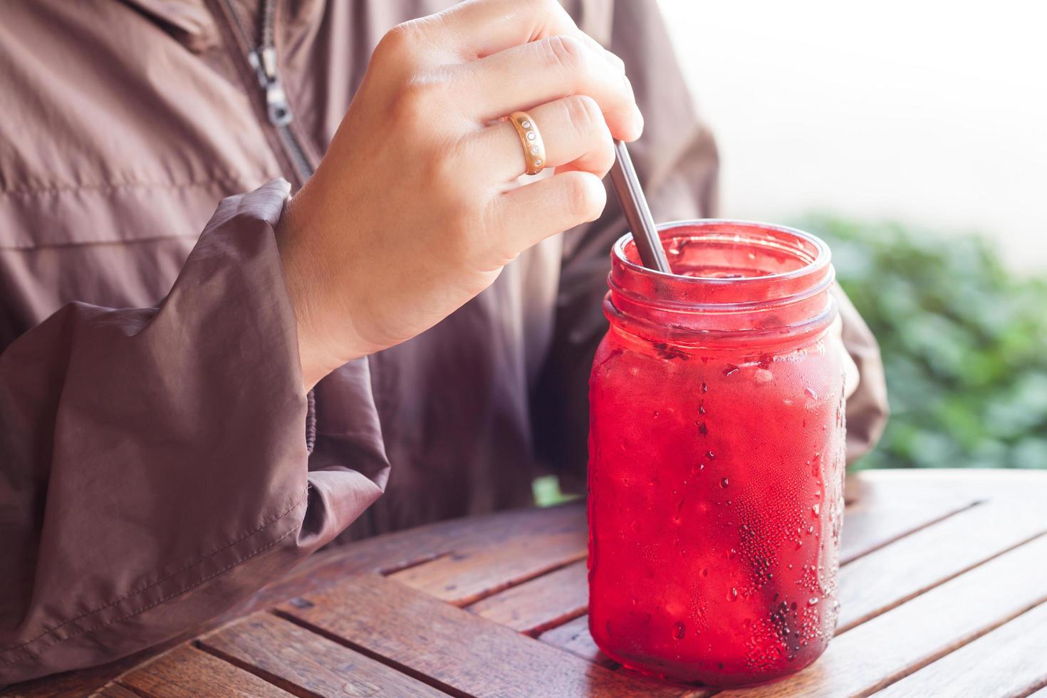 Hand holding a straw of a glass jar photo