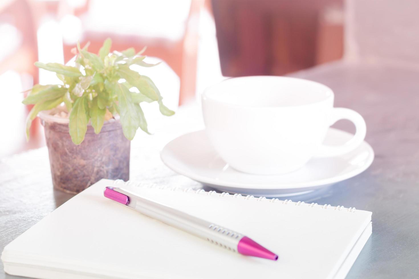 cuaderno con café y planta. foto