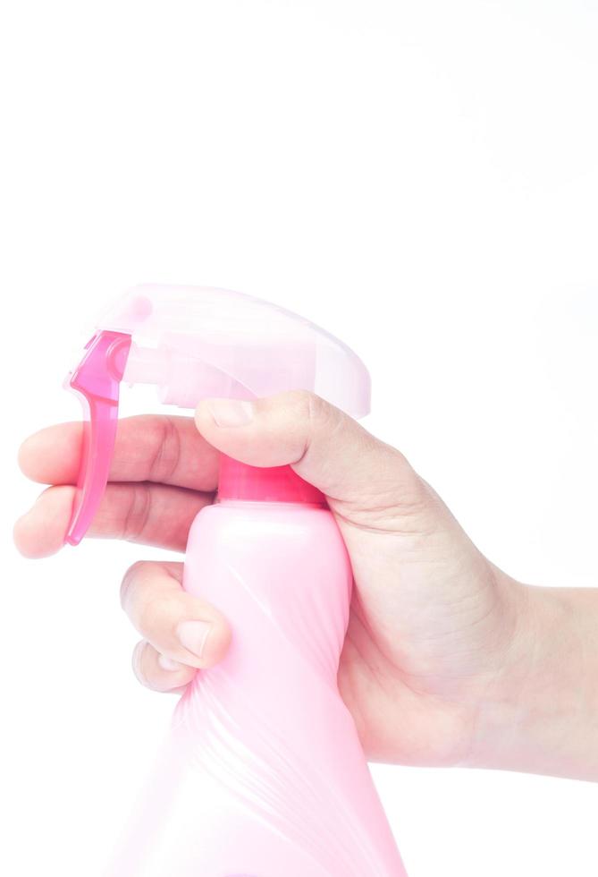 mano sosteniendo una botella de spray rosa foto