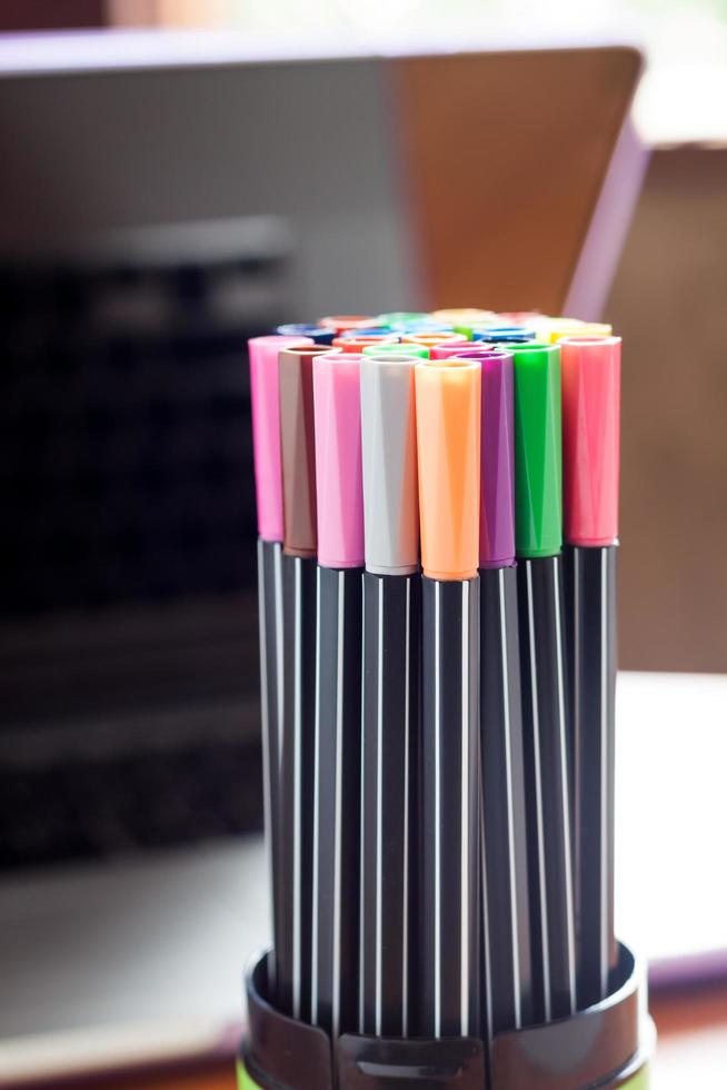 Colorful pens in a cup holder photo