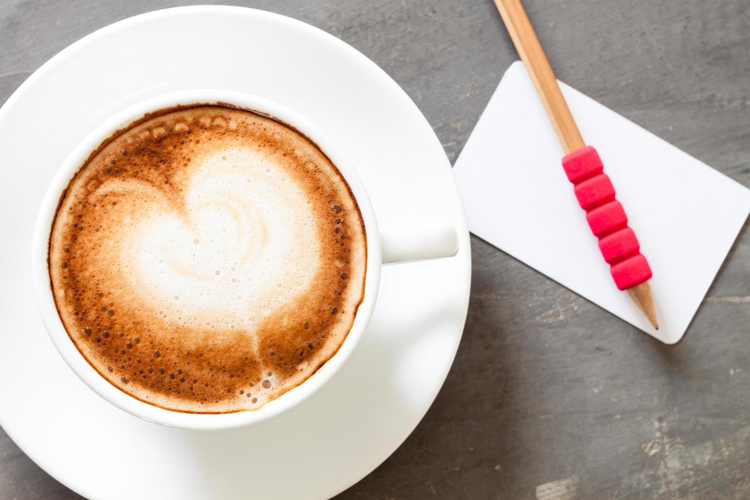 Top view of a latte with a name card and a pencil photo
