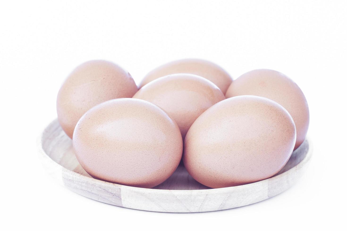 Brown eggs on a wooden tray photo