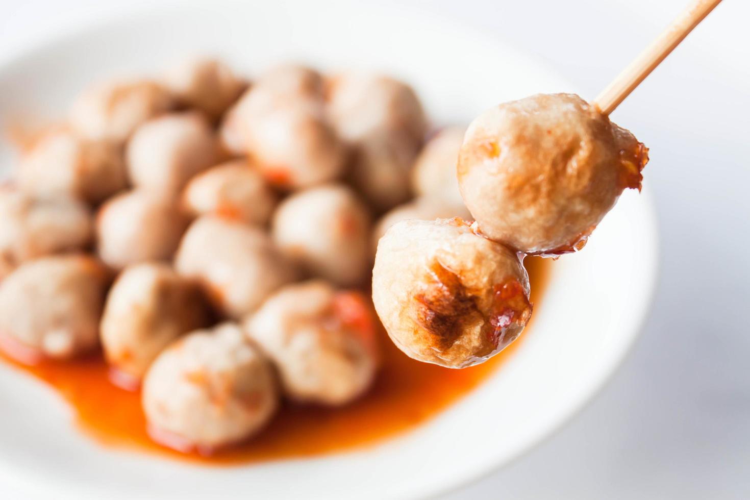 Pork meatballs dipped in sauce photo
