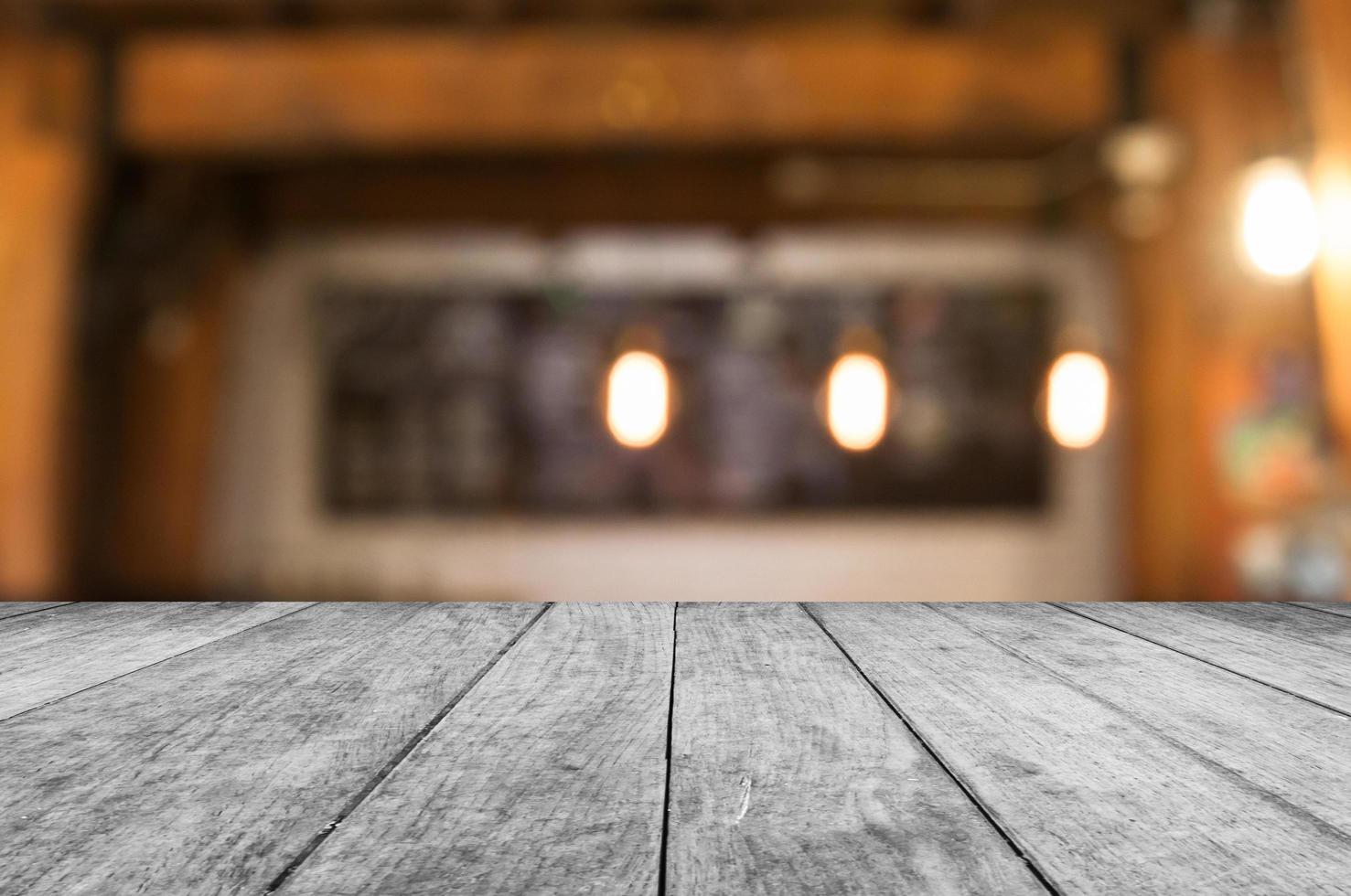 Mesa de madera blanca con una cafetería borrosa foto