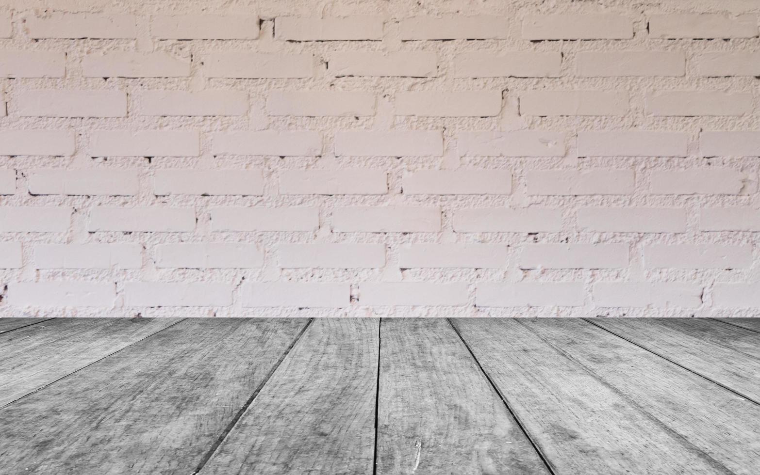 Grey wood table against a white brick wall photo
