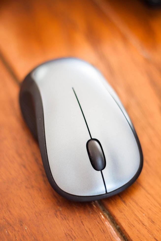 Silver wireless mouse on a wood table photo