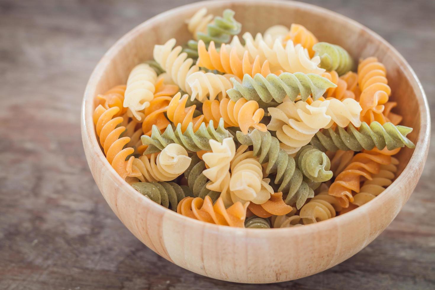 Pasta fusili en un cuenco de madera foto