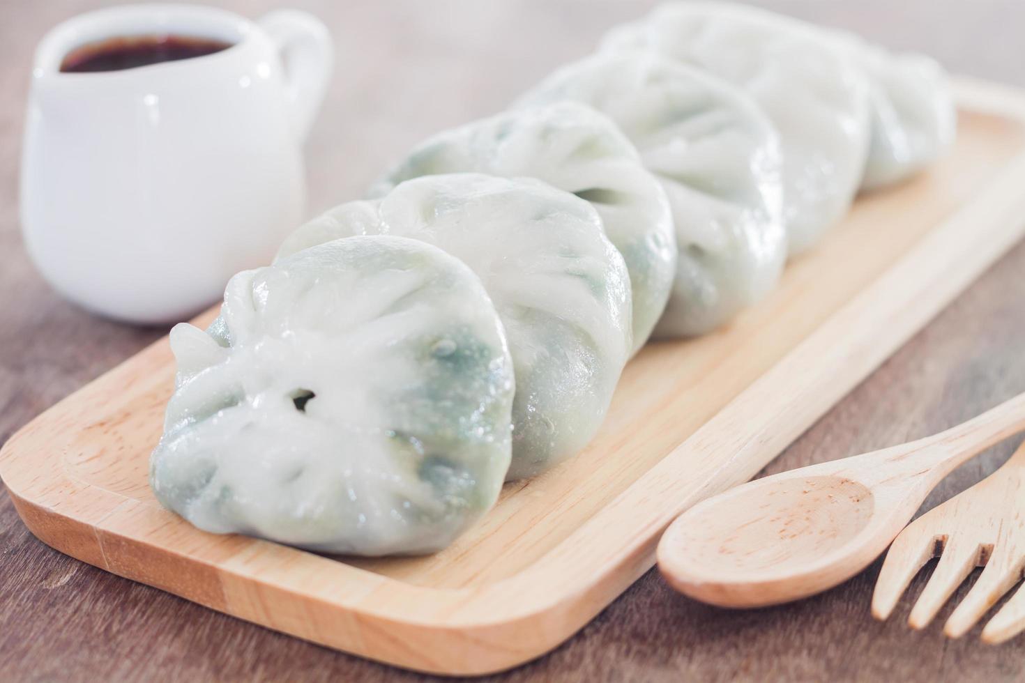 Close-up de dim sum en una bandeja de madera foto