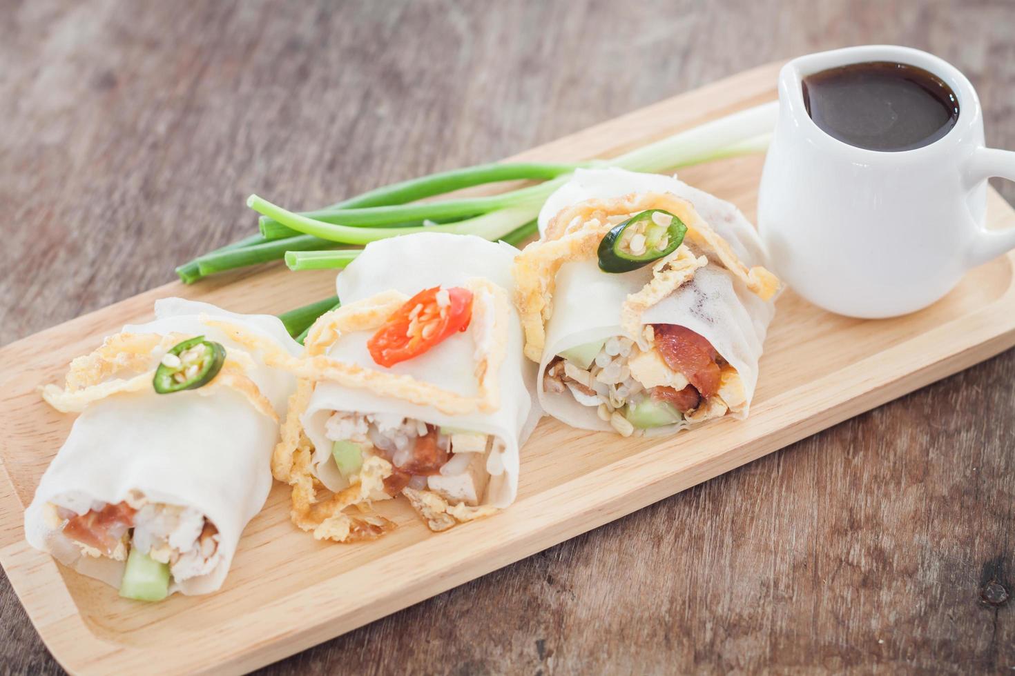 Spring rolls and sauce on a wooden tray photo