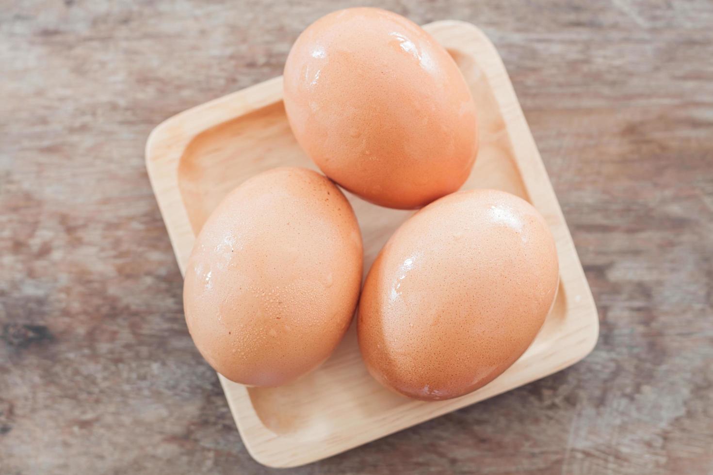 Fresh eggs on a wooden plate photo