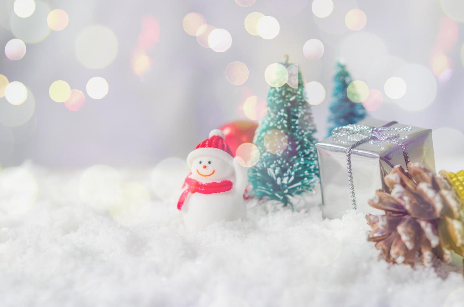 adornos navideños en miniatura en la nieve foto