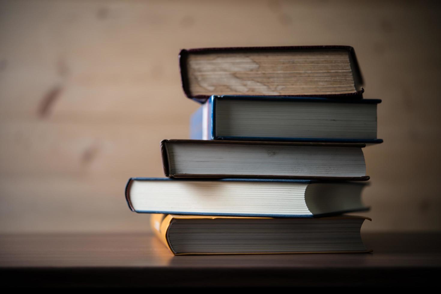 Stack of books on wooden table photo