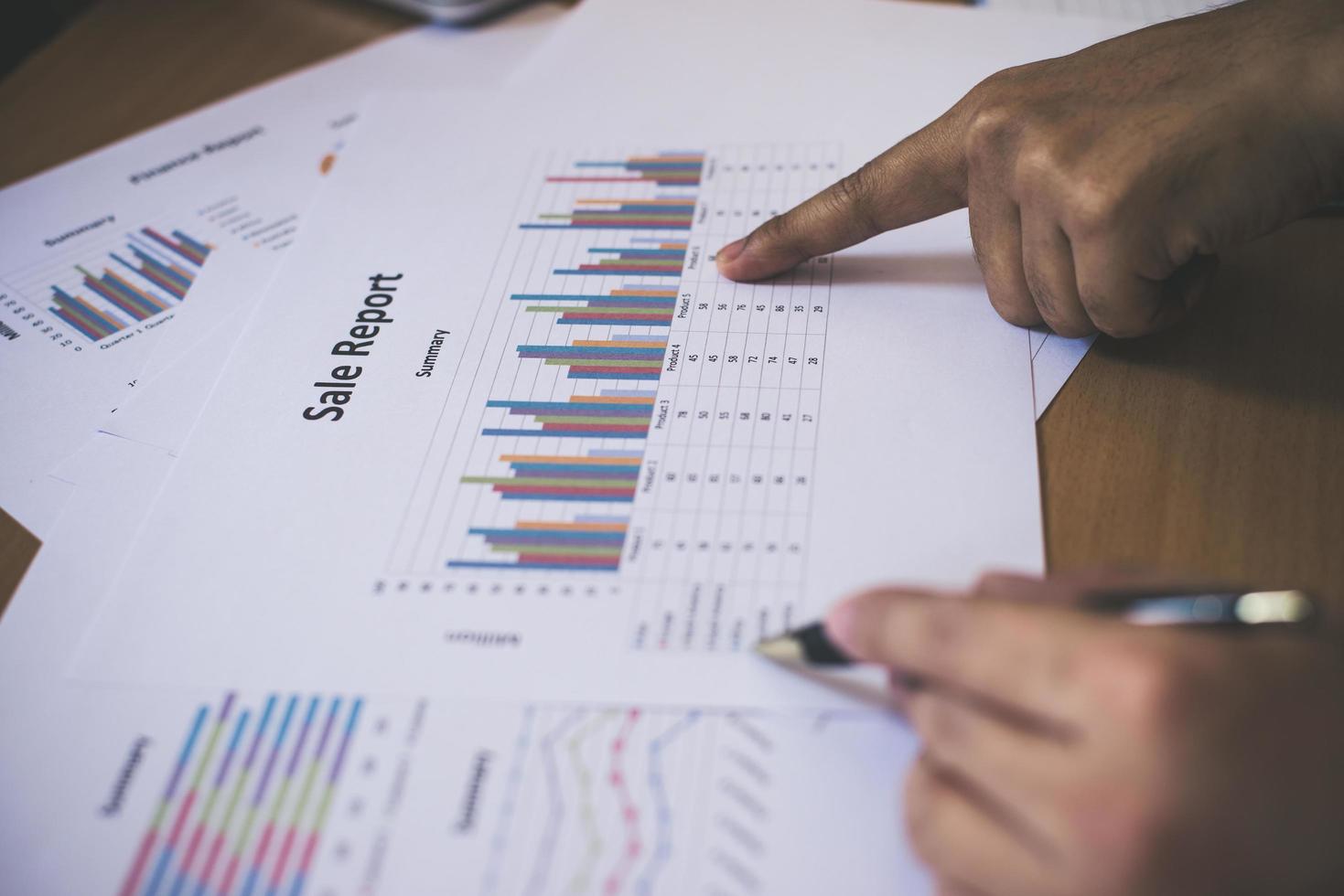 Group of business partners pointing to graph sheet photo