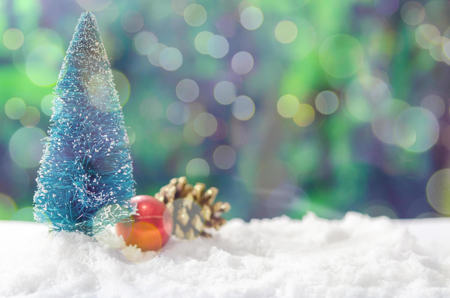 Árboles de Navidad en miniatura y adornos en la nieve. foto