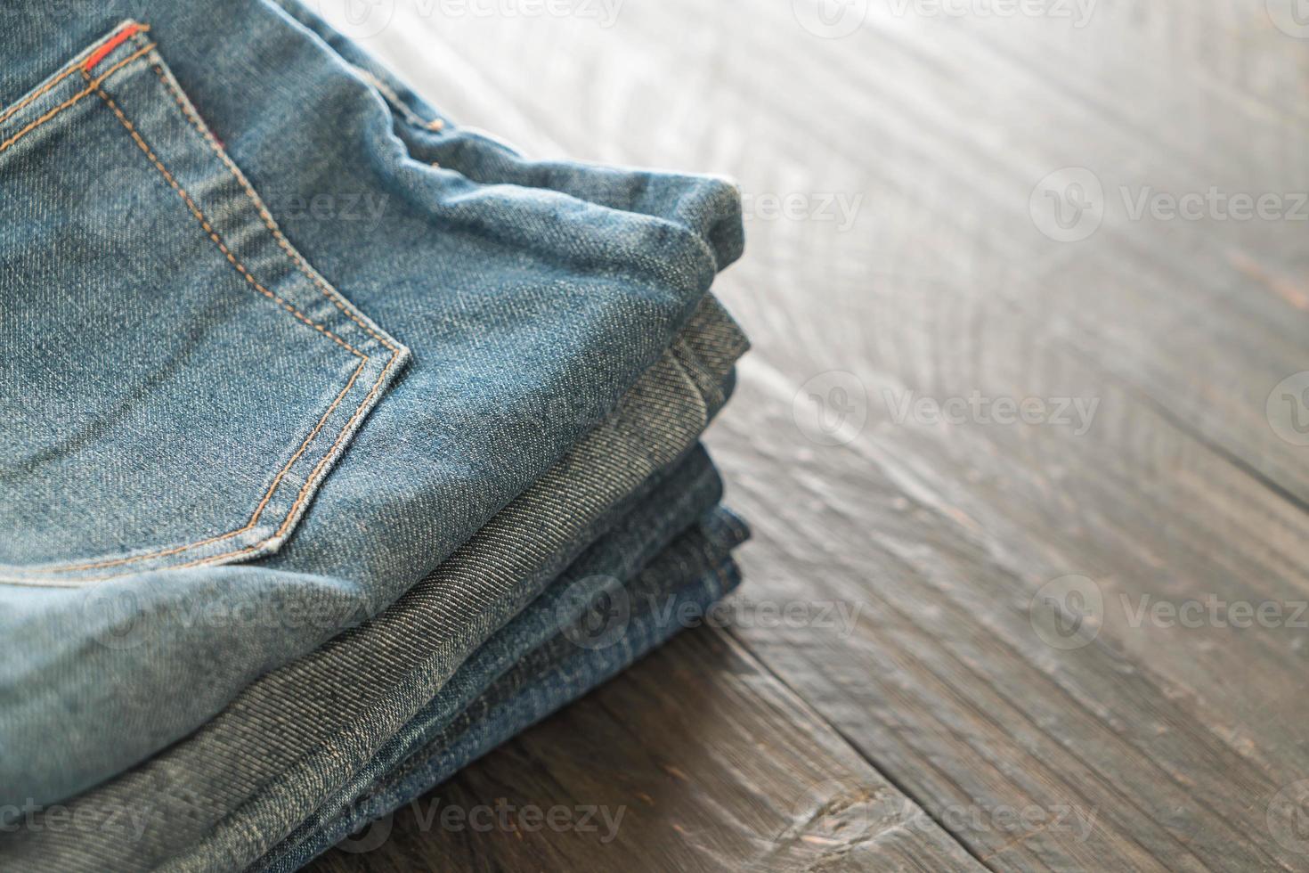 Stack of jeans on wood floor photo