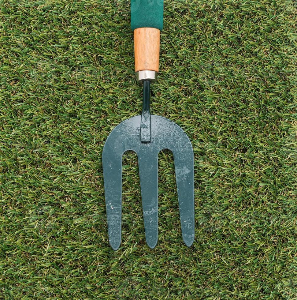 Small garden rake on grass photo