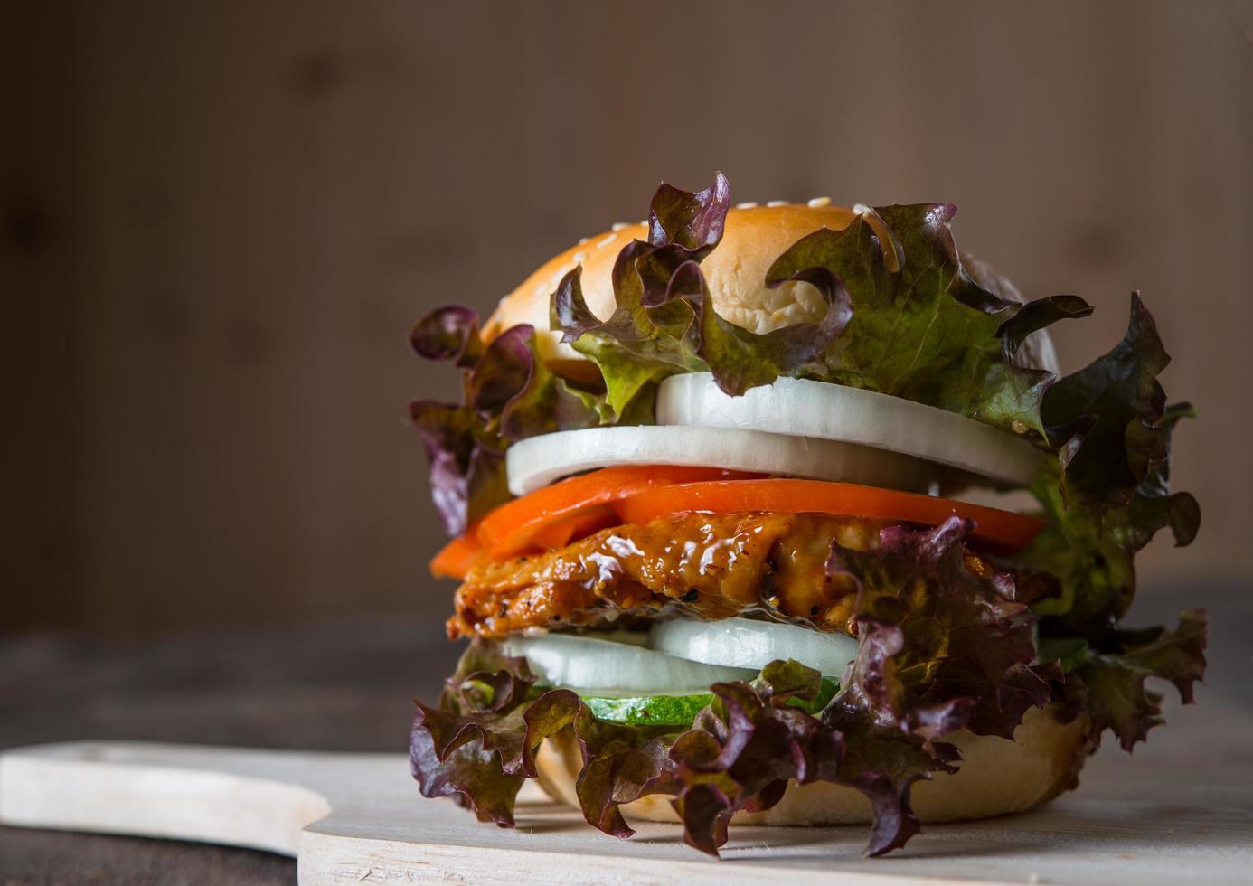 hamburguesa casera de pollo con lechuga, tomate y cebolla foto