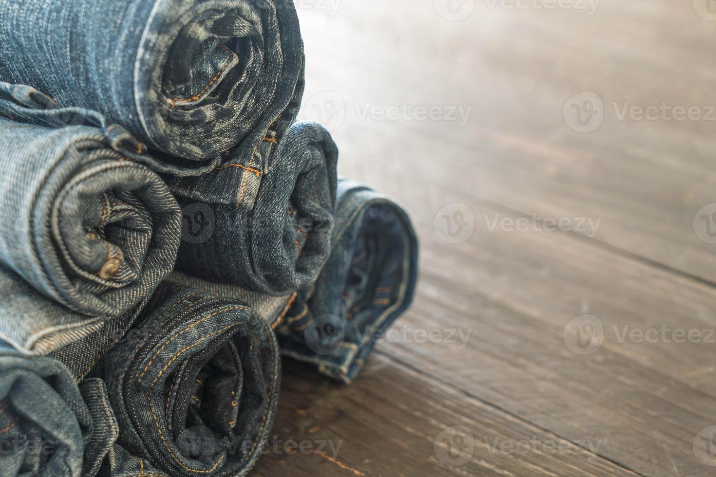 Stack of jeans on wood floor photo