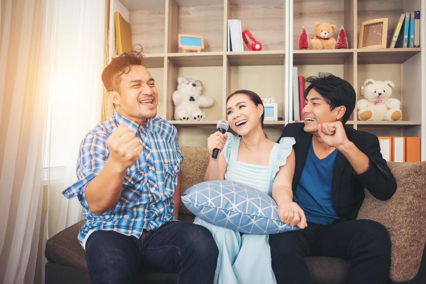 grupo de amigos cantando una canción juntos en su sala de estar foto