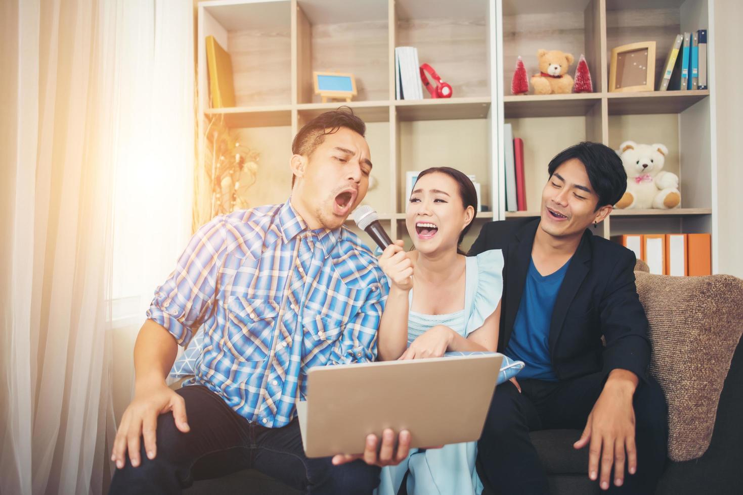 grupo de amigos cantando una canción juntos en su sala de estar foto