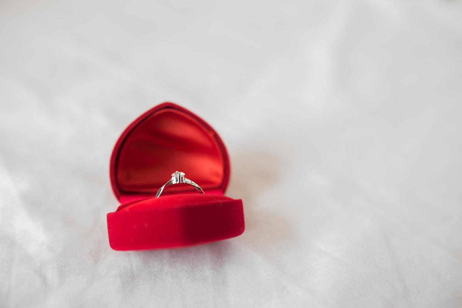 anillo de bodas en una caja en la cama foto