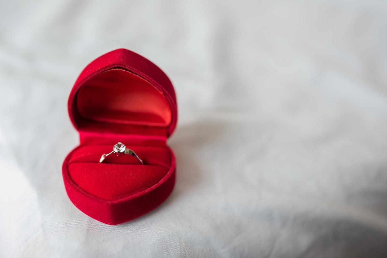 anillo de bodas en una caja en la cama foto