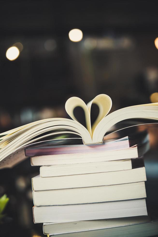 Piles of books on a table over a blurred library background photo