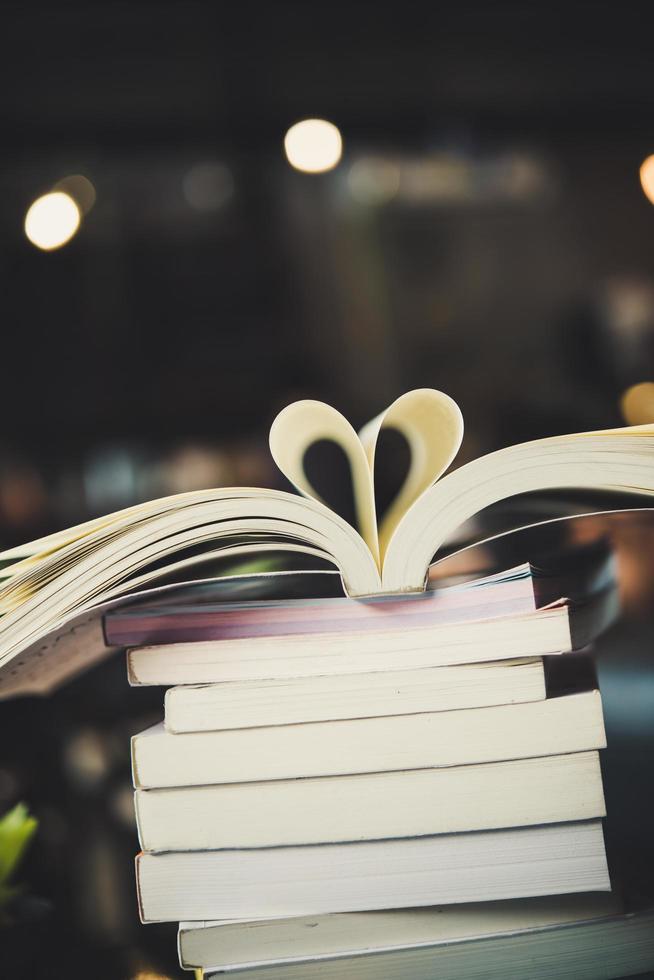 Montones de libros sobre una mesa sobre un fondo de biblioteca borrosa foto