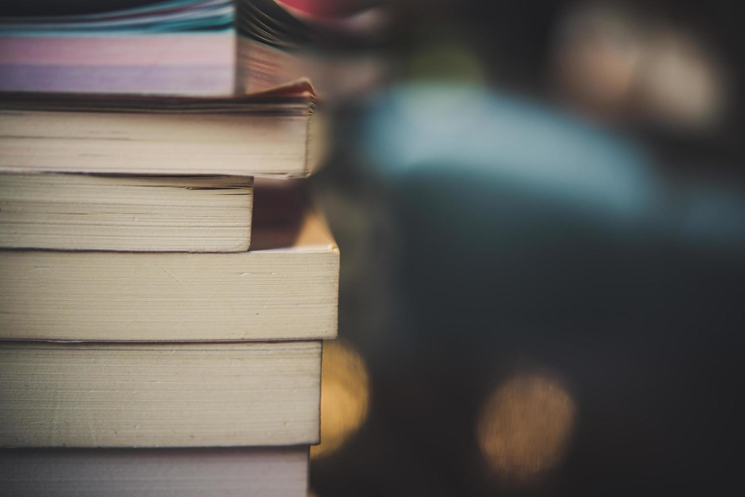 Piles of books on a table over a blurred library background photo