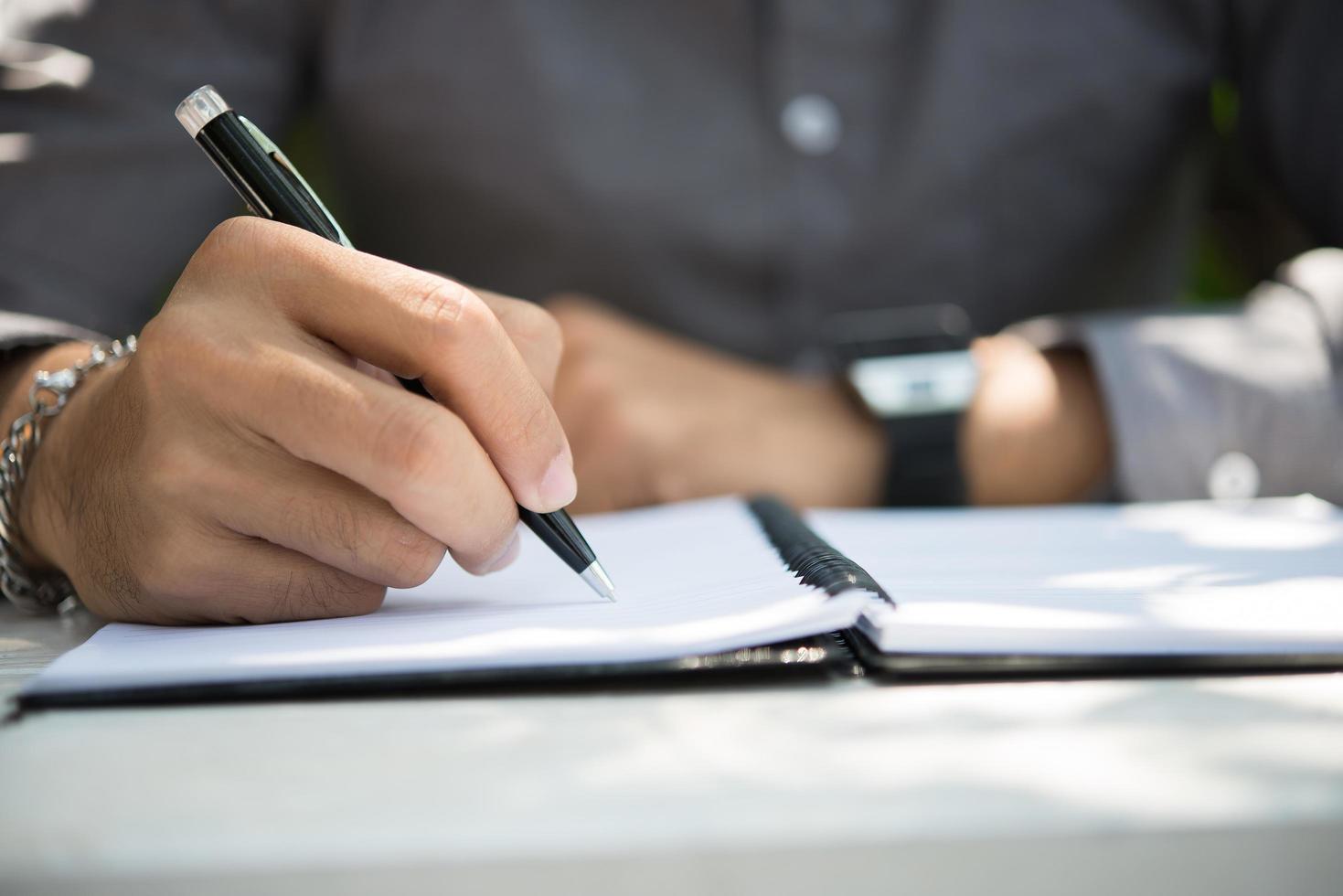 Man writing on notepad while sitting relaxing at home garden photo