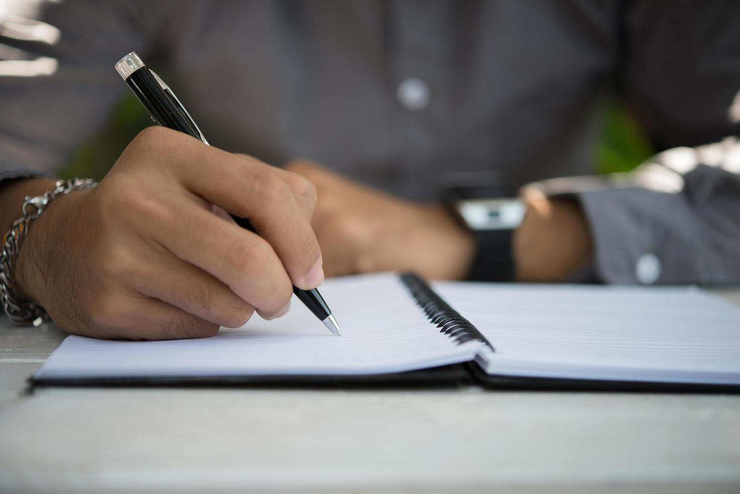 Man writing on notepad while sitting relaxing at home garden photo