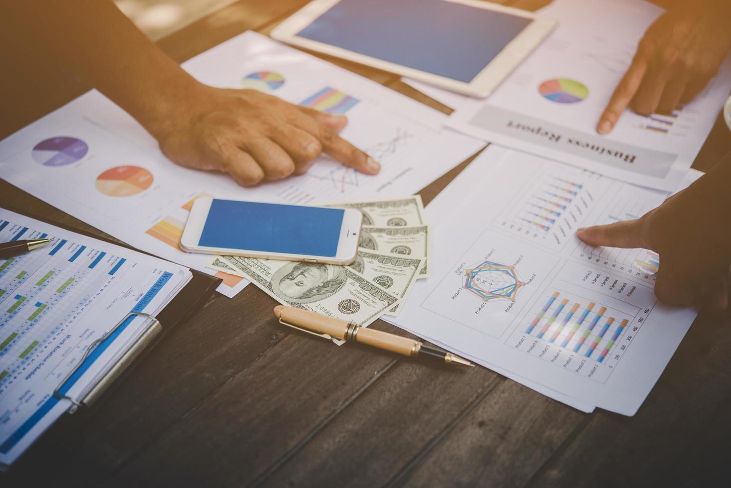 Group of business people analyze graphs at meeting photo