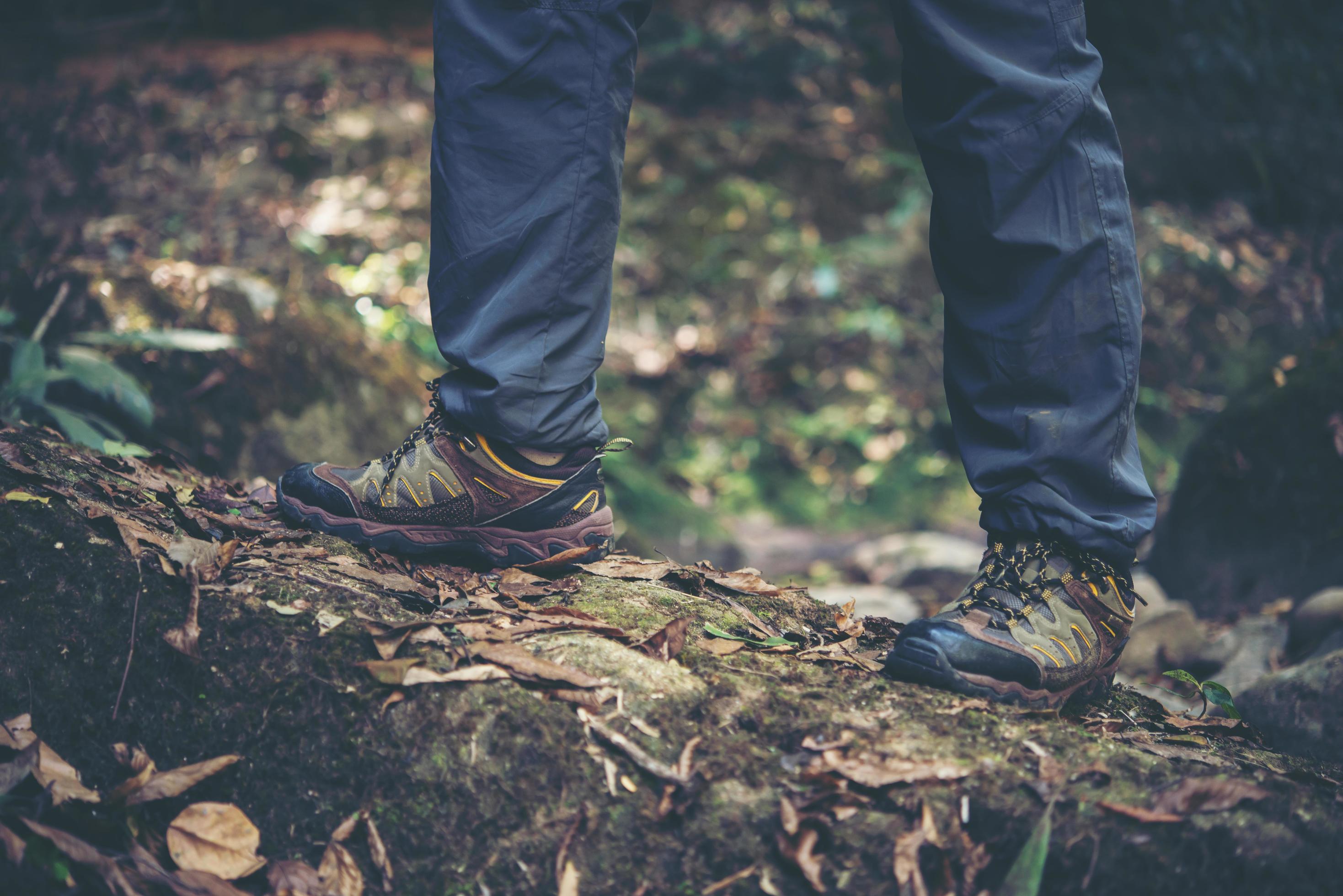 Cerrar senderismo hombre con botas de trekking caminando en el bosque