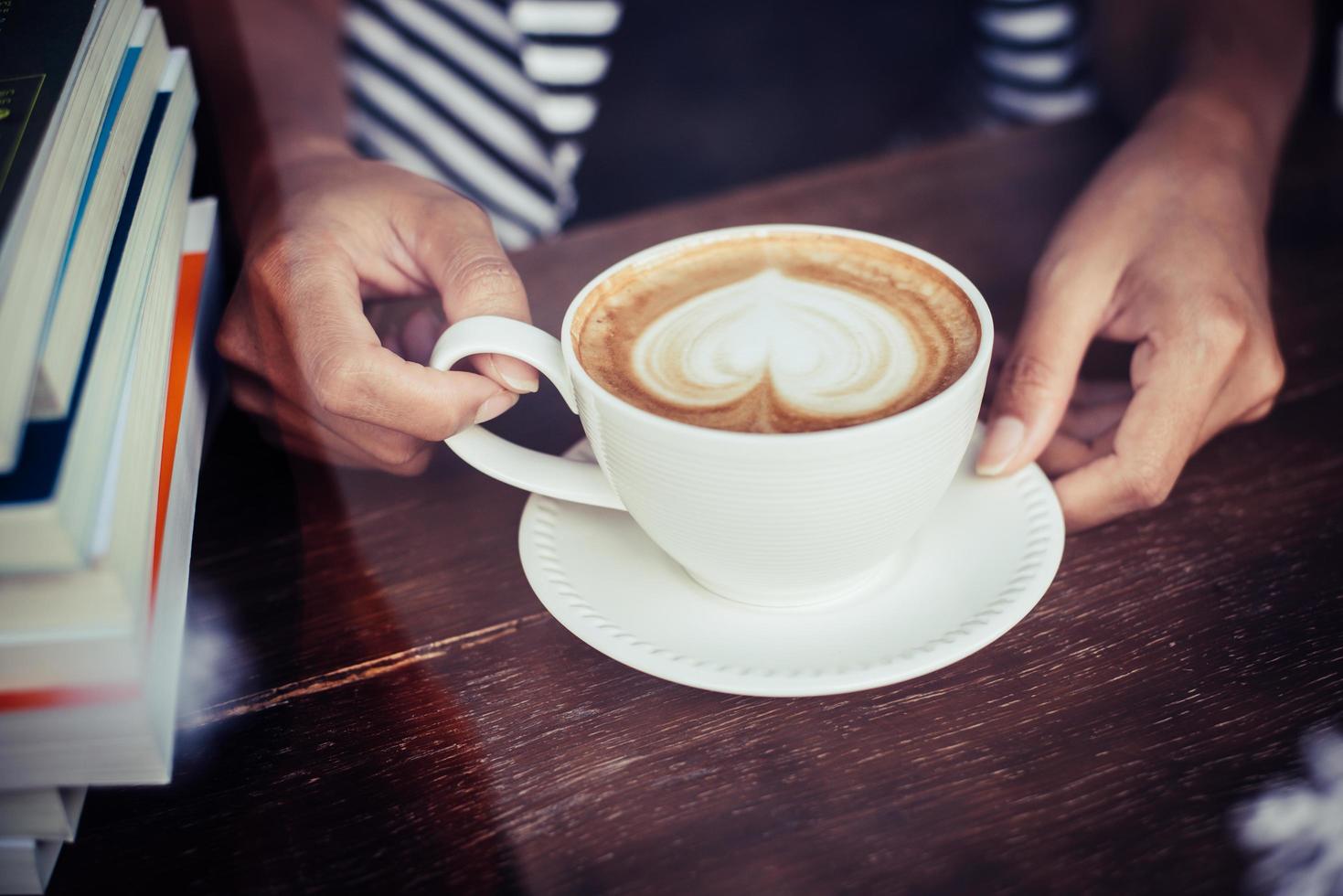 Woman's hands relaxing with coffee at cafe photo