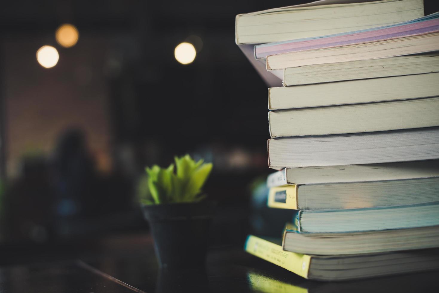 Montones de libros sobre una mesa sobre un fondo de biblioteca borrosa foto